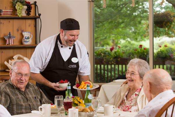 Signature programs at Juniper include great menu selections and service - chef serving seniors a sampler
