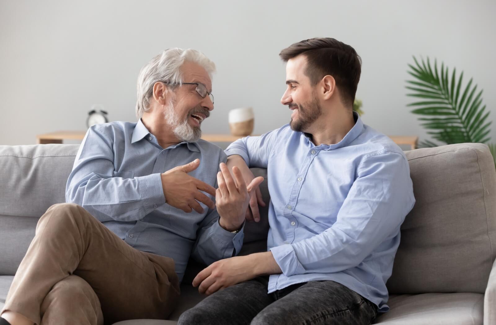 A happy senior man and his happy son having a conversation.