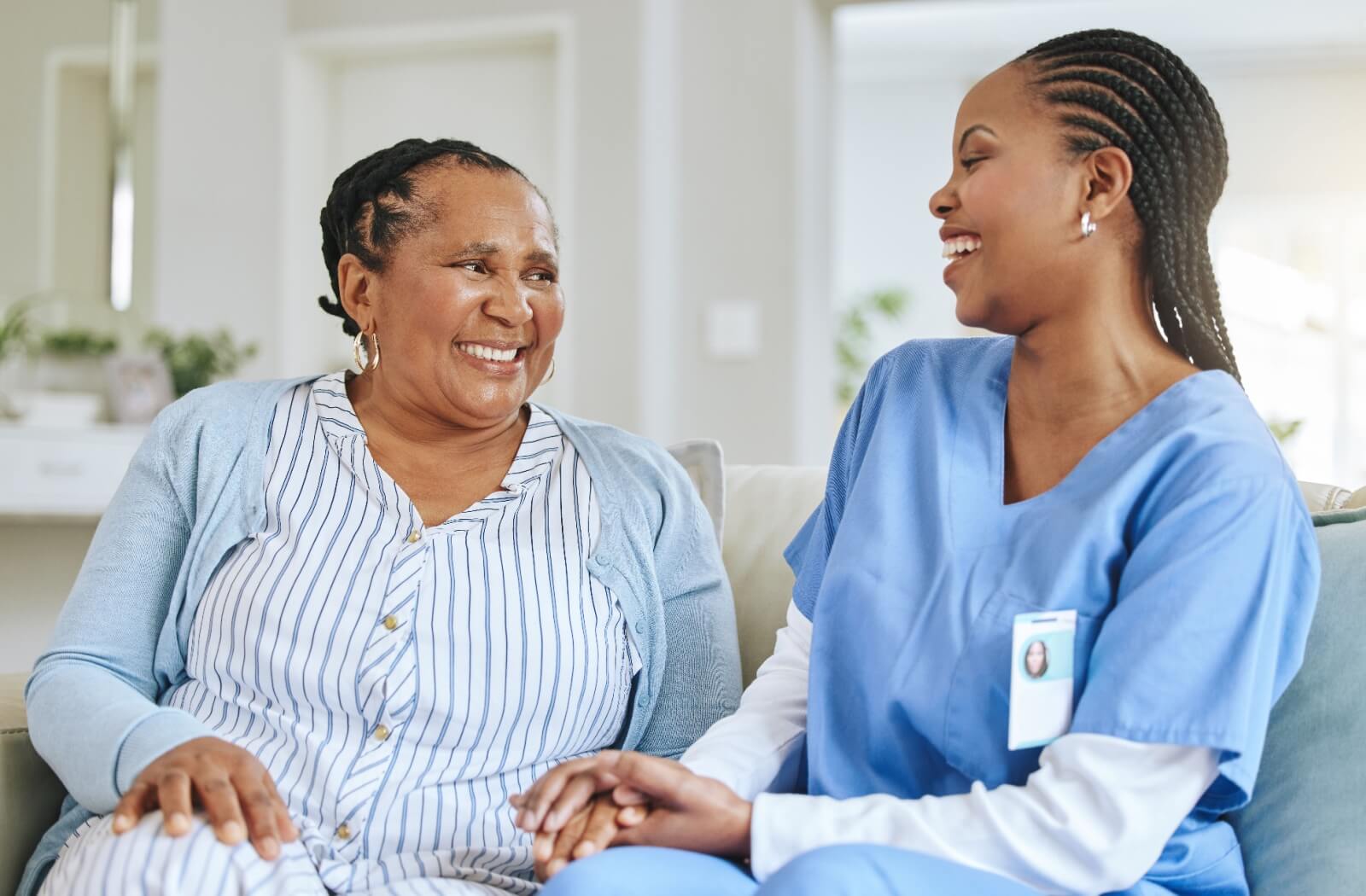 A senior woman and a nurse having a fun conversation with each other.