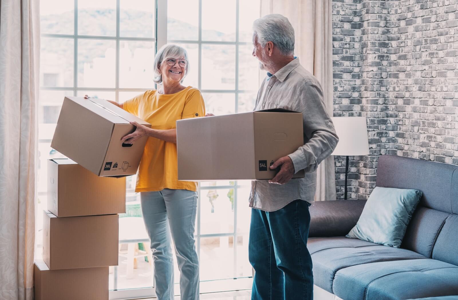 Two older adults packing boxes to transition into an assisted living community.