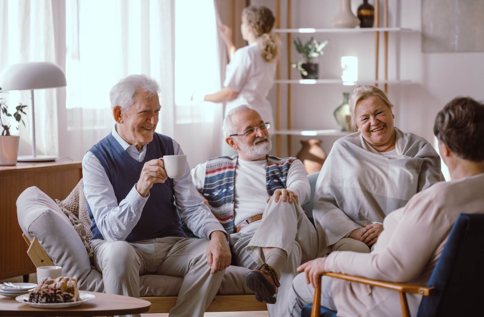 A group of older adults socializing in a common area of an assisted living community.