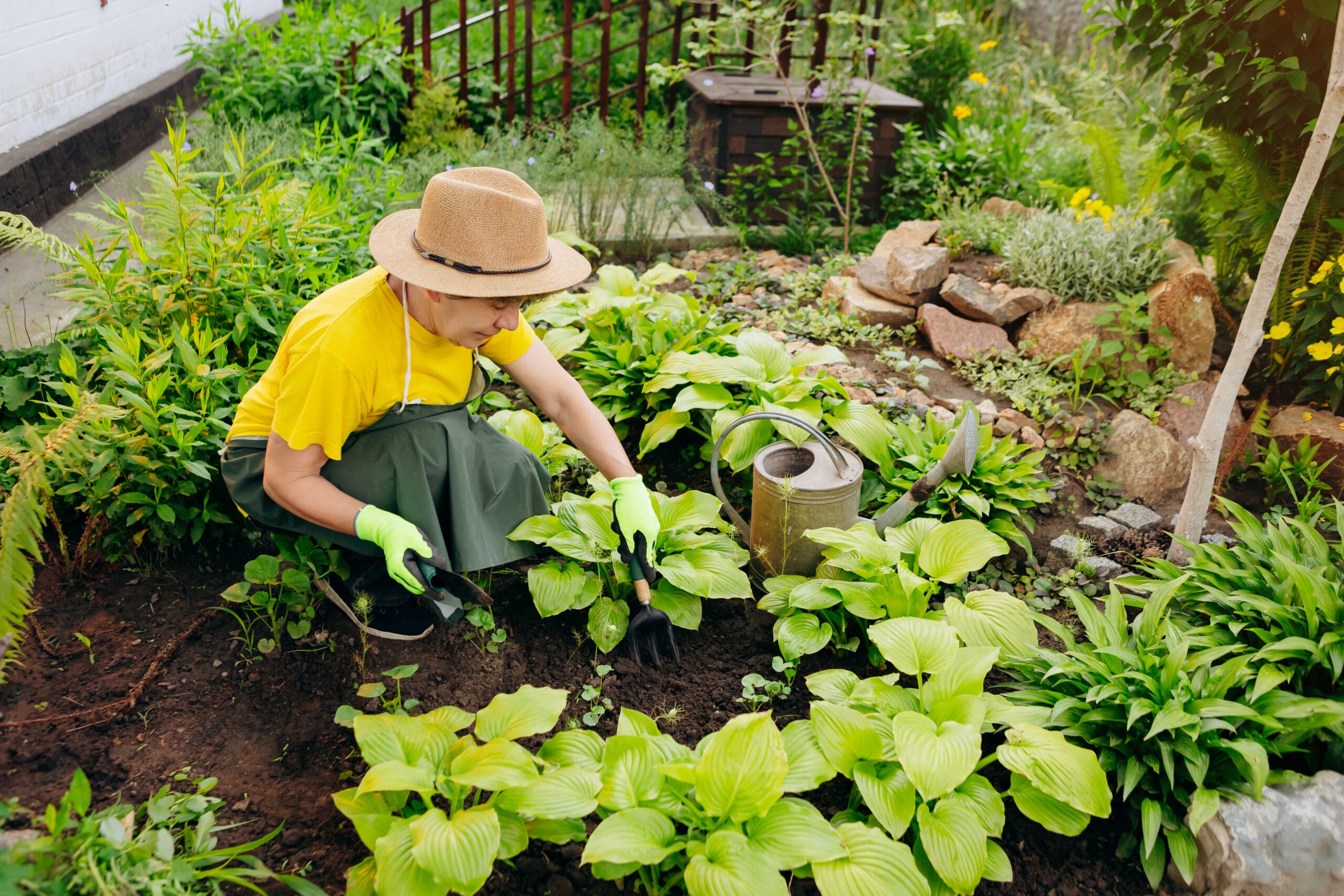 An older adult woman gardening in her personal care home.