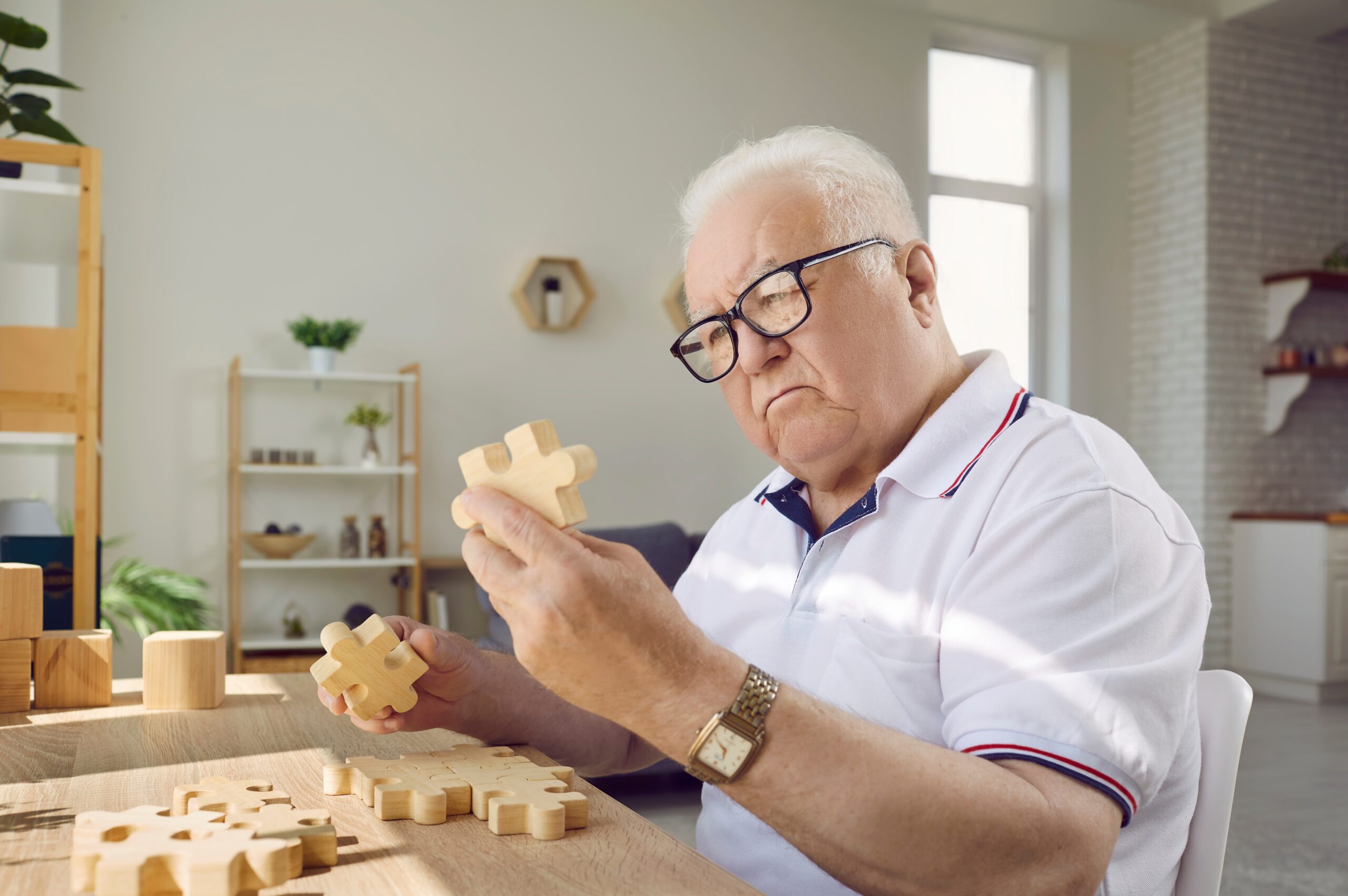An older adult resident with a cognitive impairment faces challenges with a puzzle.