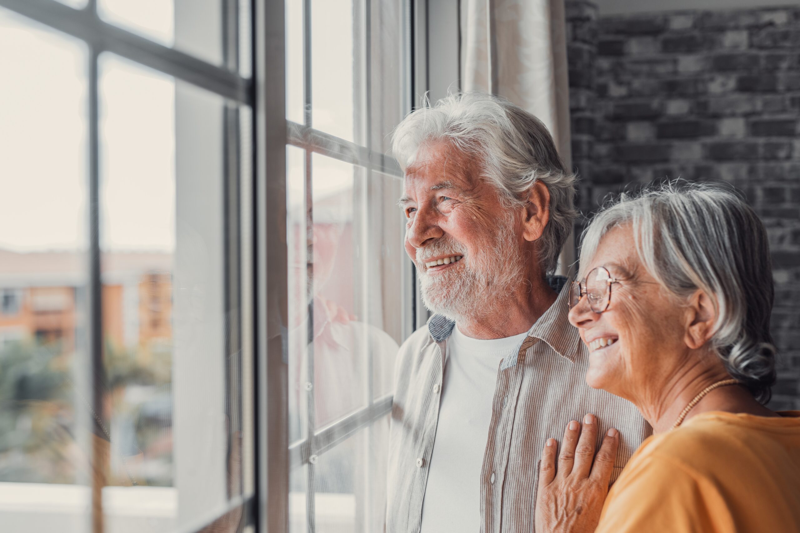 A joyful older adult couple admiring their new senior living community, radiating happiness and contentment.