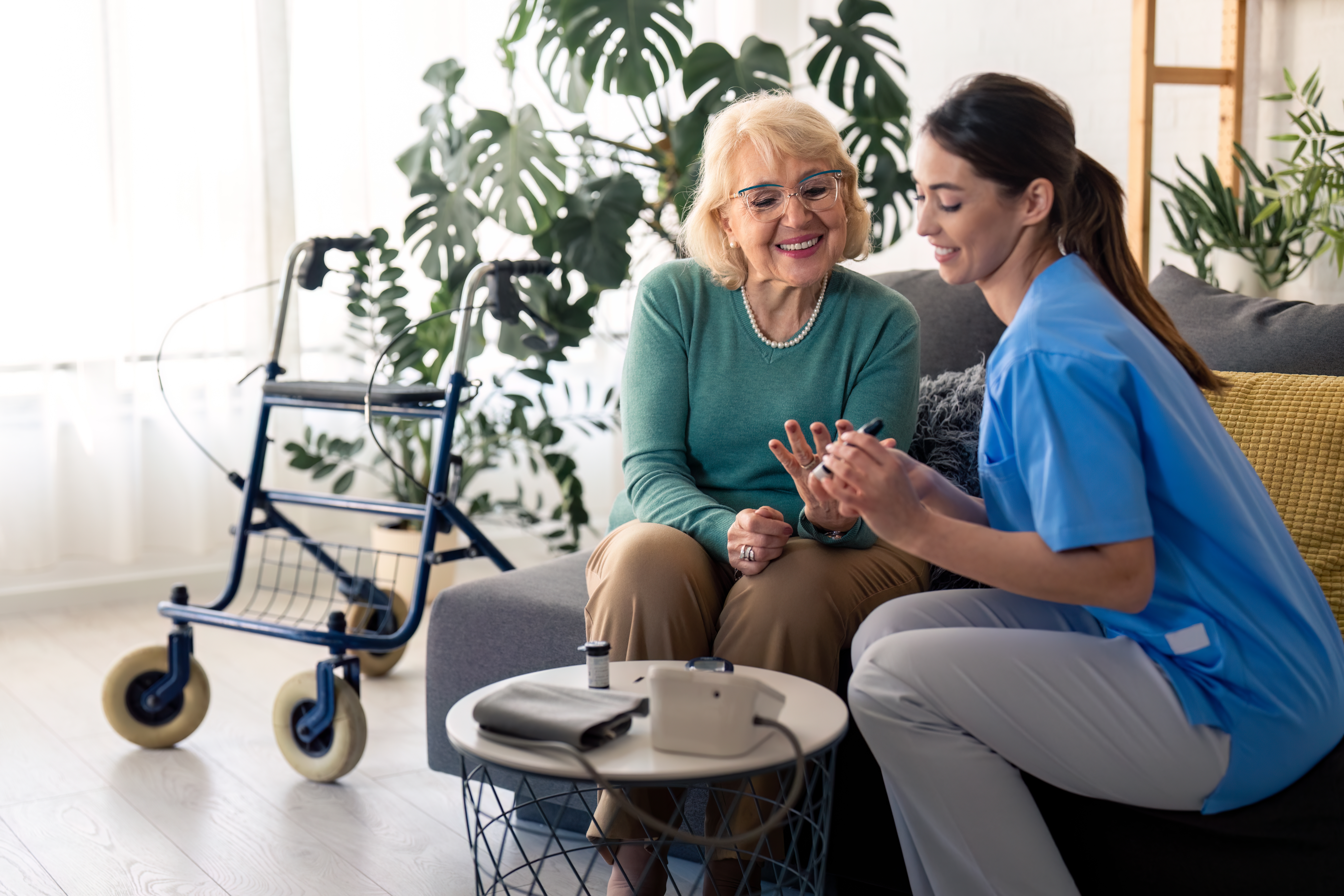 An older adult woman being shown how to manage her diabetes by an assisted living caregiver.