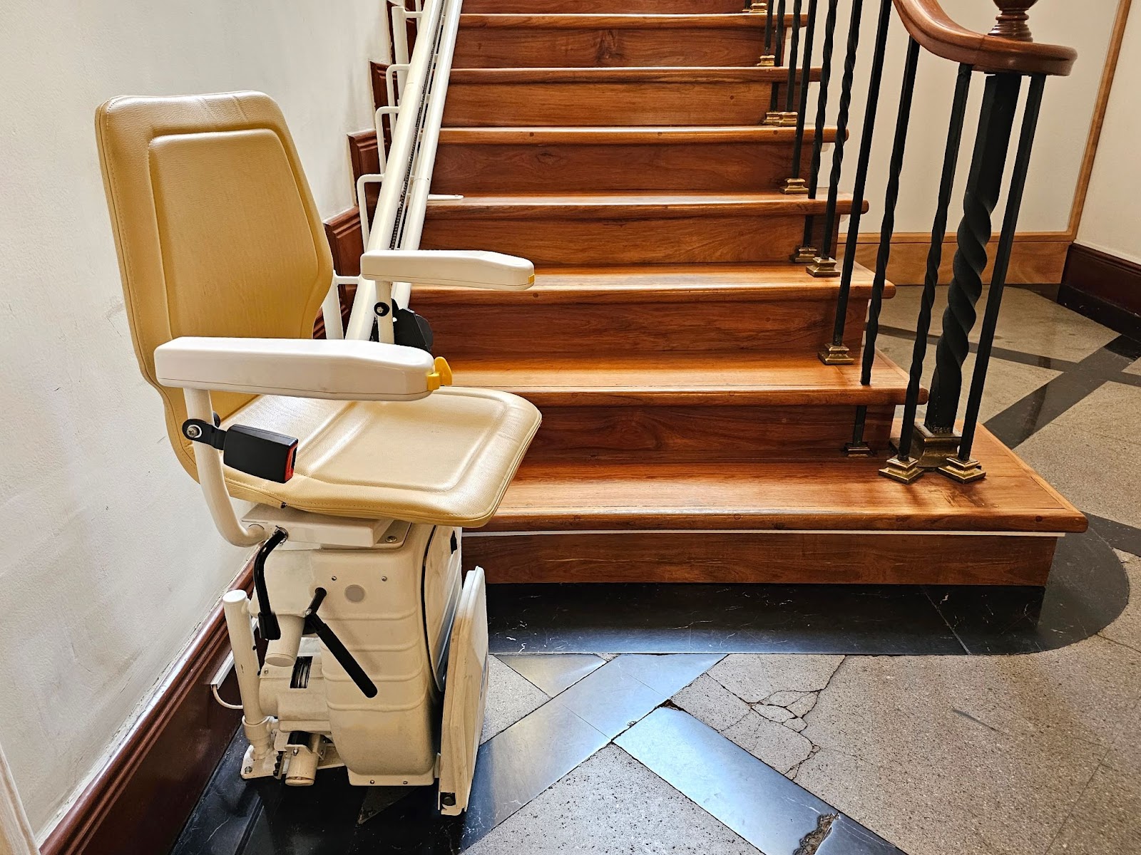 A chair lift attached to a wooden staircase.