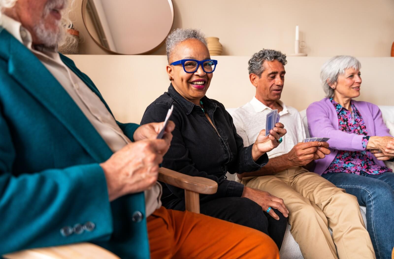 A diverse group of older adults playing cards together.