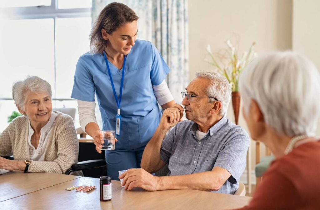 A nurse helping a resident take his medicine.