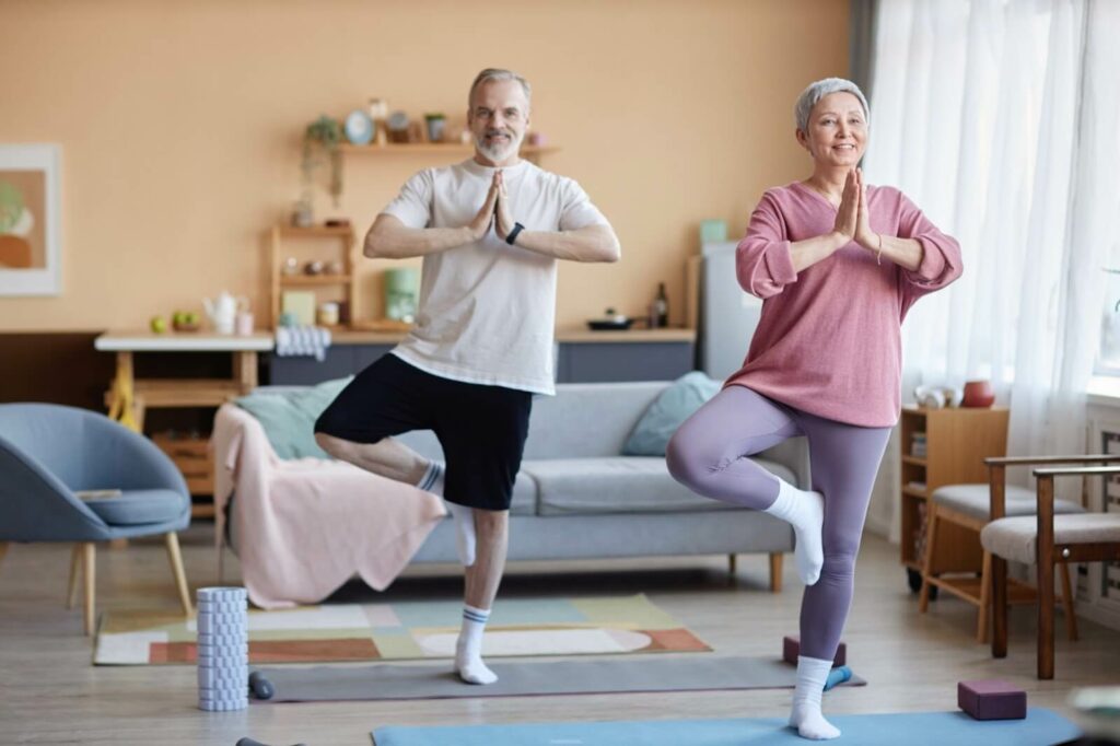 Older adults performing balance exercises in their living room.