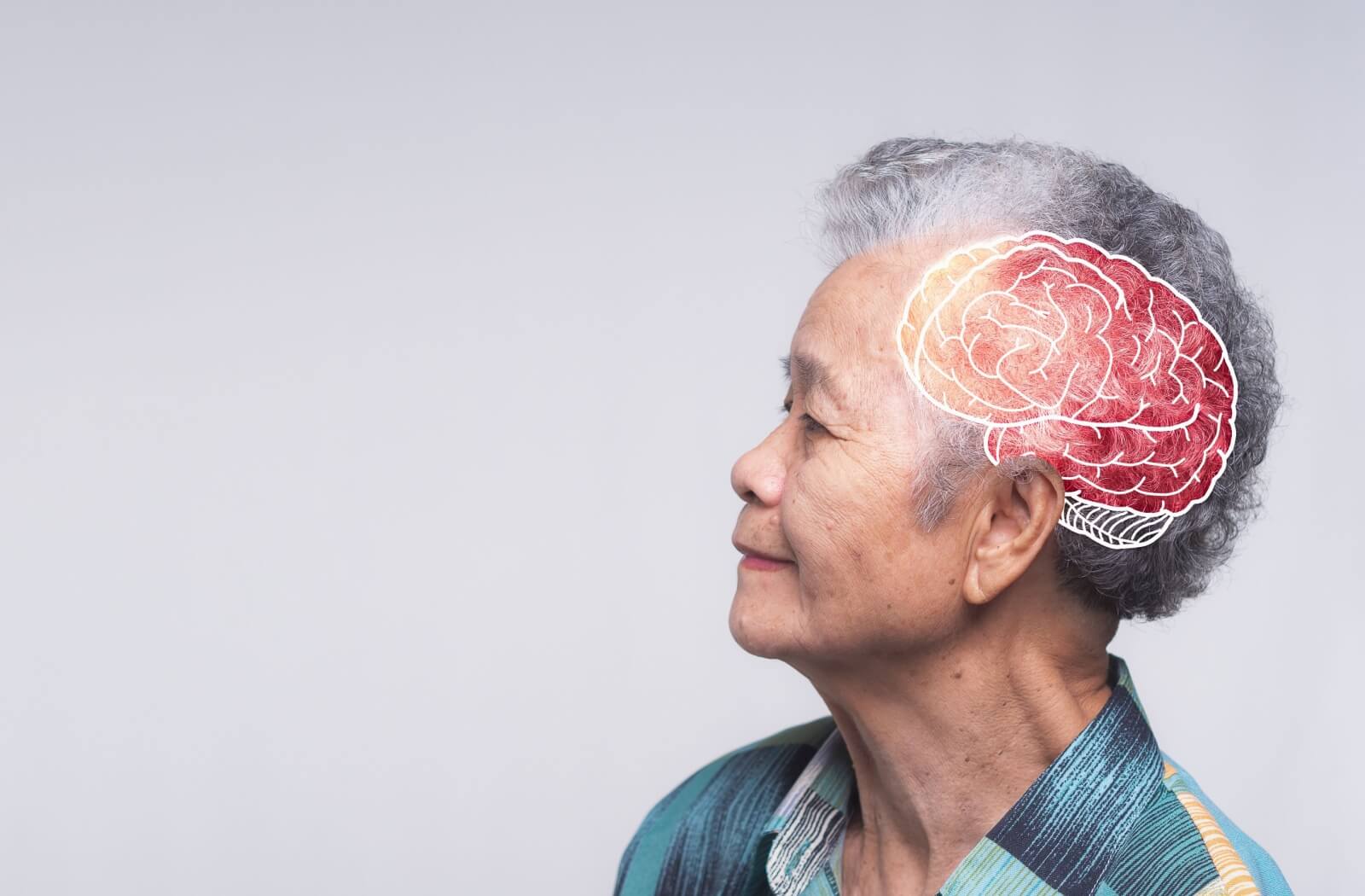 A mature woman looks off to the left, a digital image of a human brain lighting up the side of her head to signify cognitive stimulation.