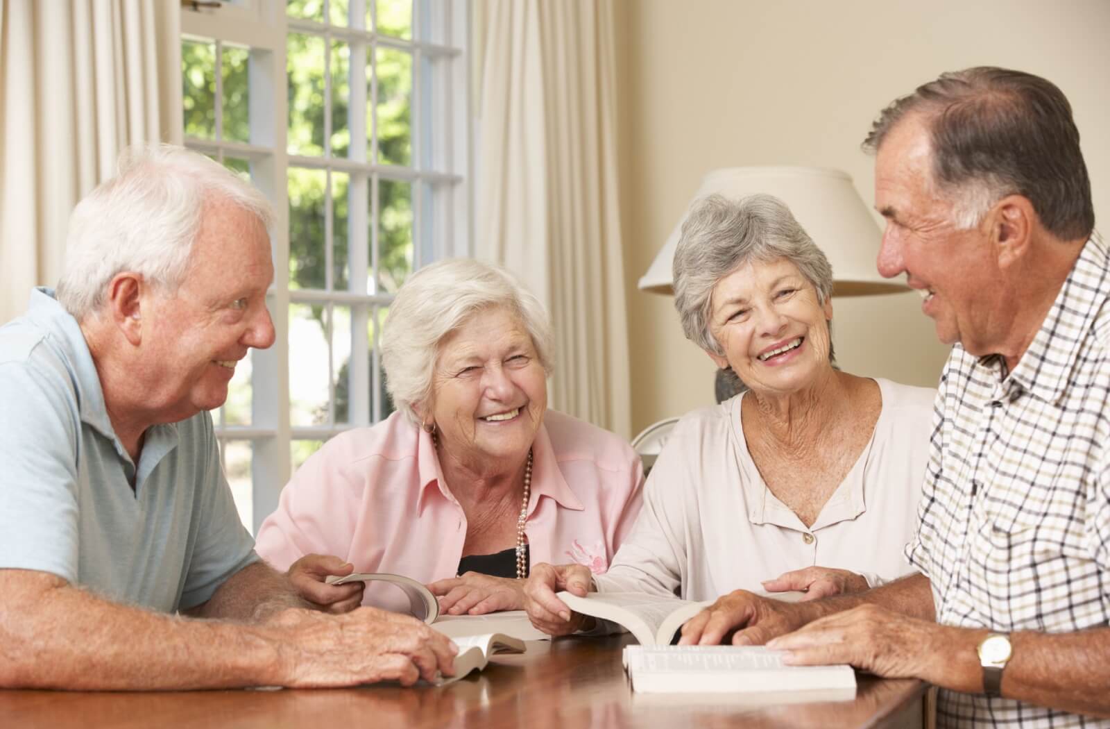 A book club of older adults reading discussing the books they're reading.