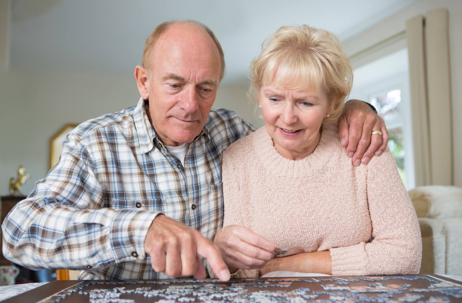 Older adult couple working together on a jigsaw puzzle, enhancing cognitive skills