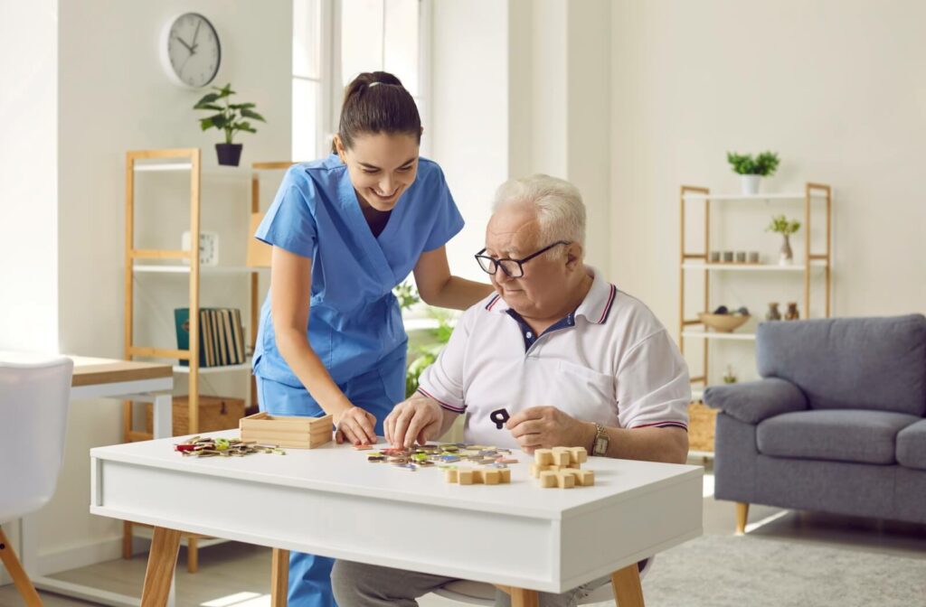An older adult engaging in cognitive puzzle games with a caregiver's assistance.