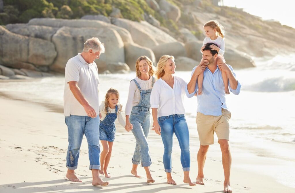 Multigenerational family walking together along the beach during a vacation.