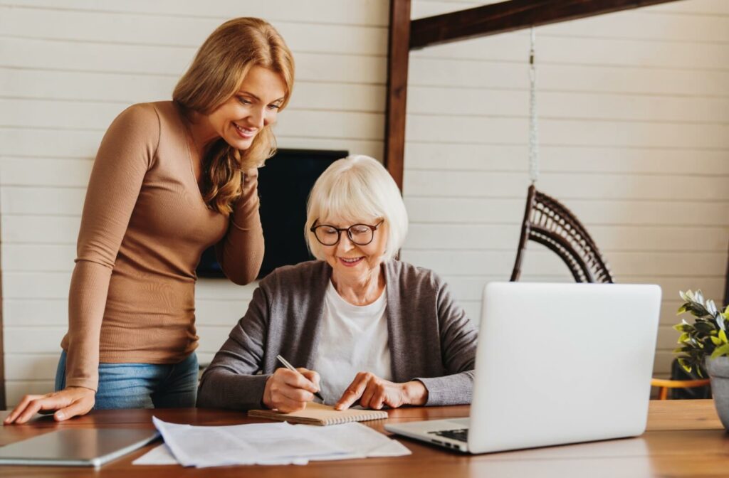 A young woman and her older adult mother go over their financials together.