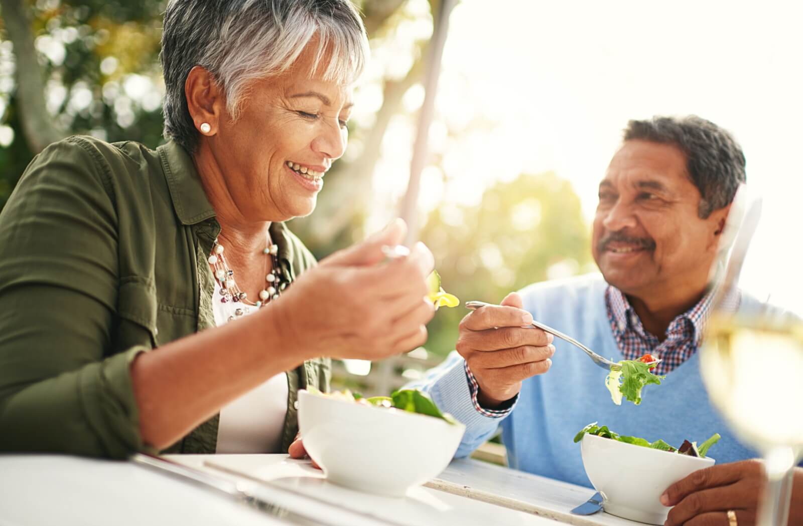 Older couple enjoying a healthy meal together outdoors.