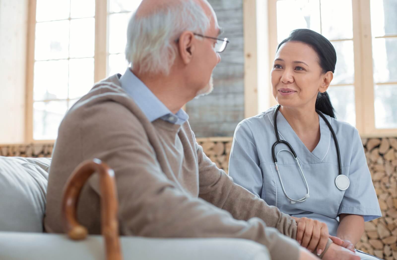 An older adult in skilled nursing care is comforted by a nurse.