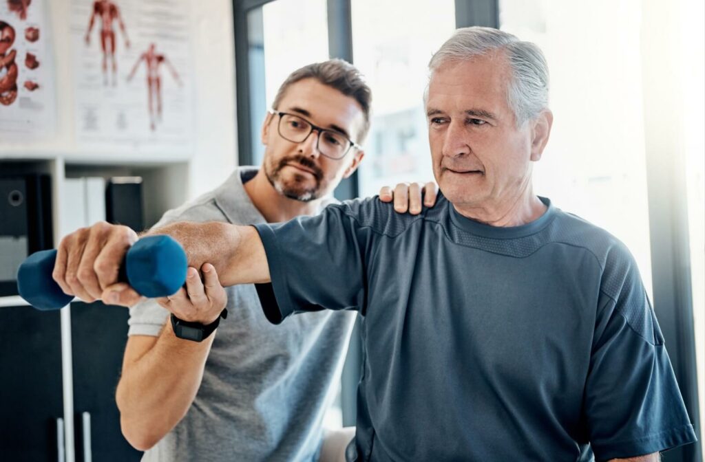 An older adult works with a caregiver to build muscles.