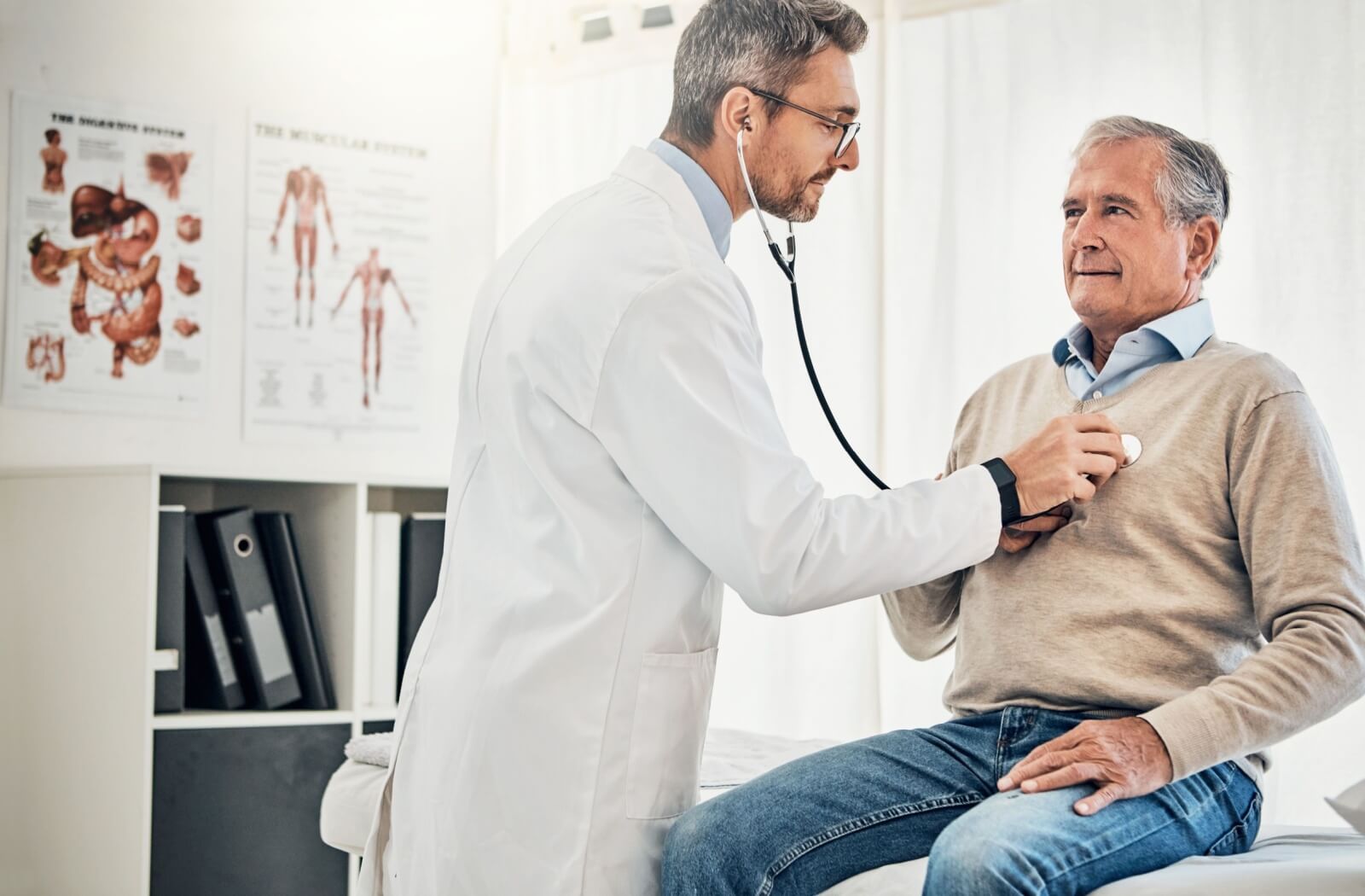 A doctor uses a stethoscope to check a patient’s heart health during a routine examination in a medical office.