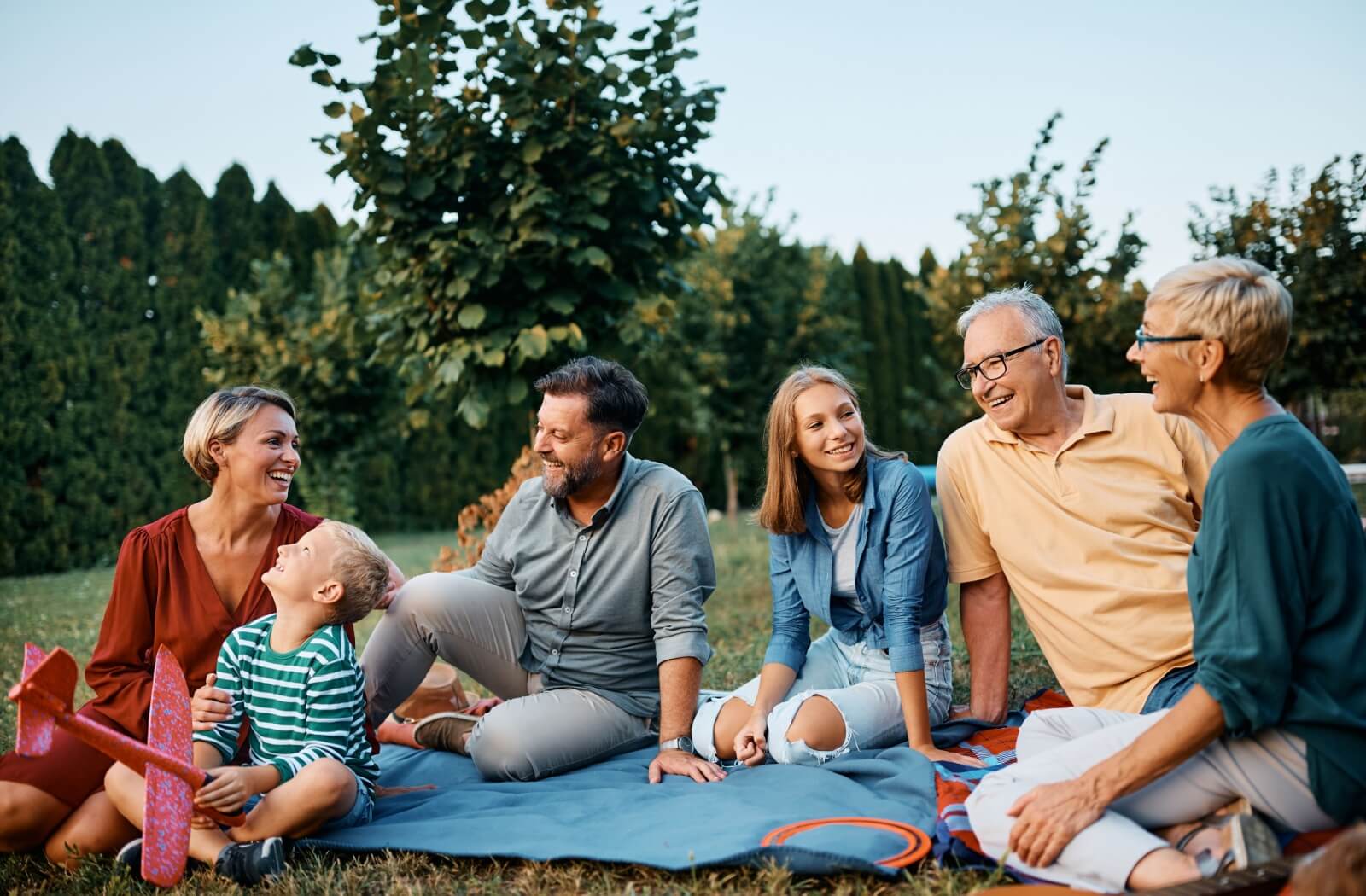 A happy extended family enjoys time spent together outdoors.