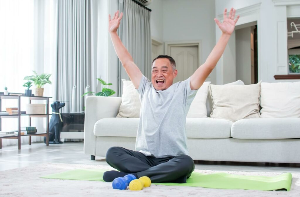 A happy older adult engages in physical exercise in their personal care home.