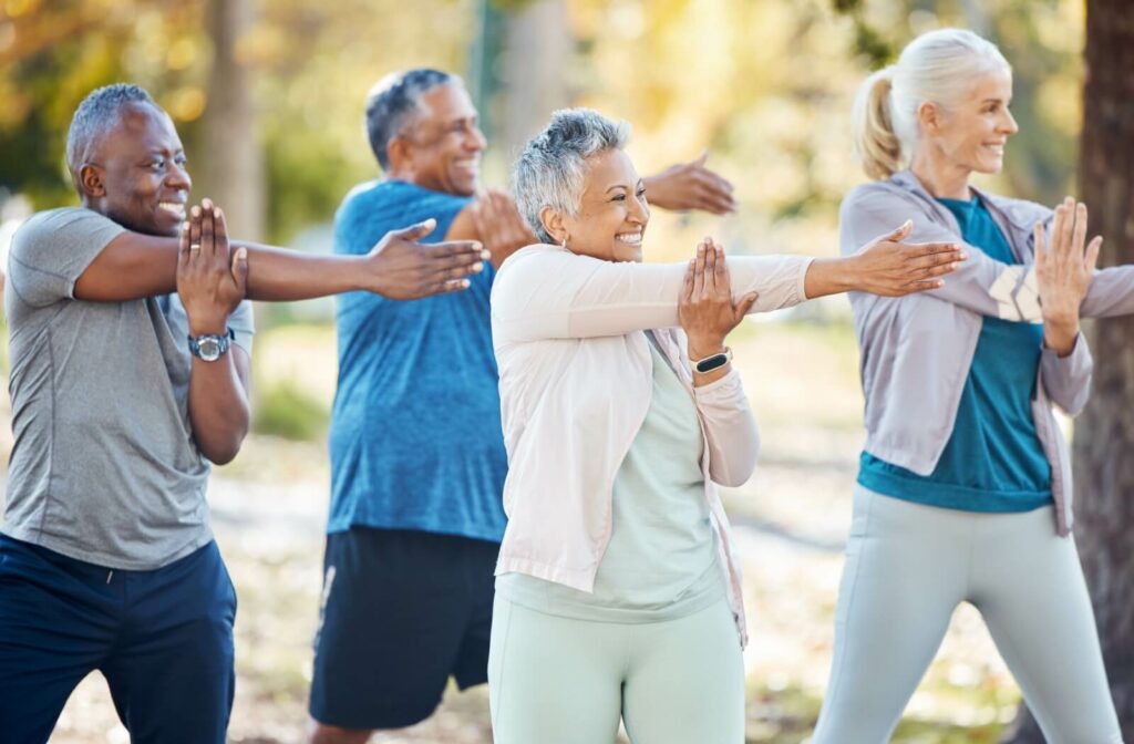 A group of older adults participating in tai chi in the park.