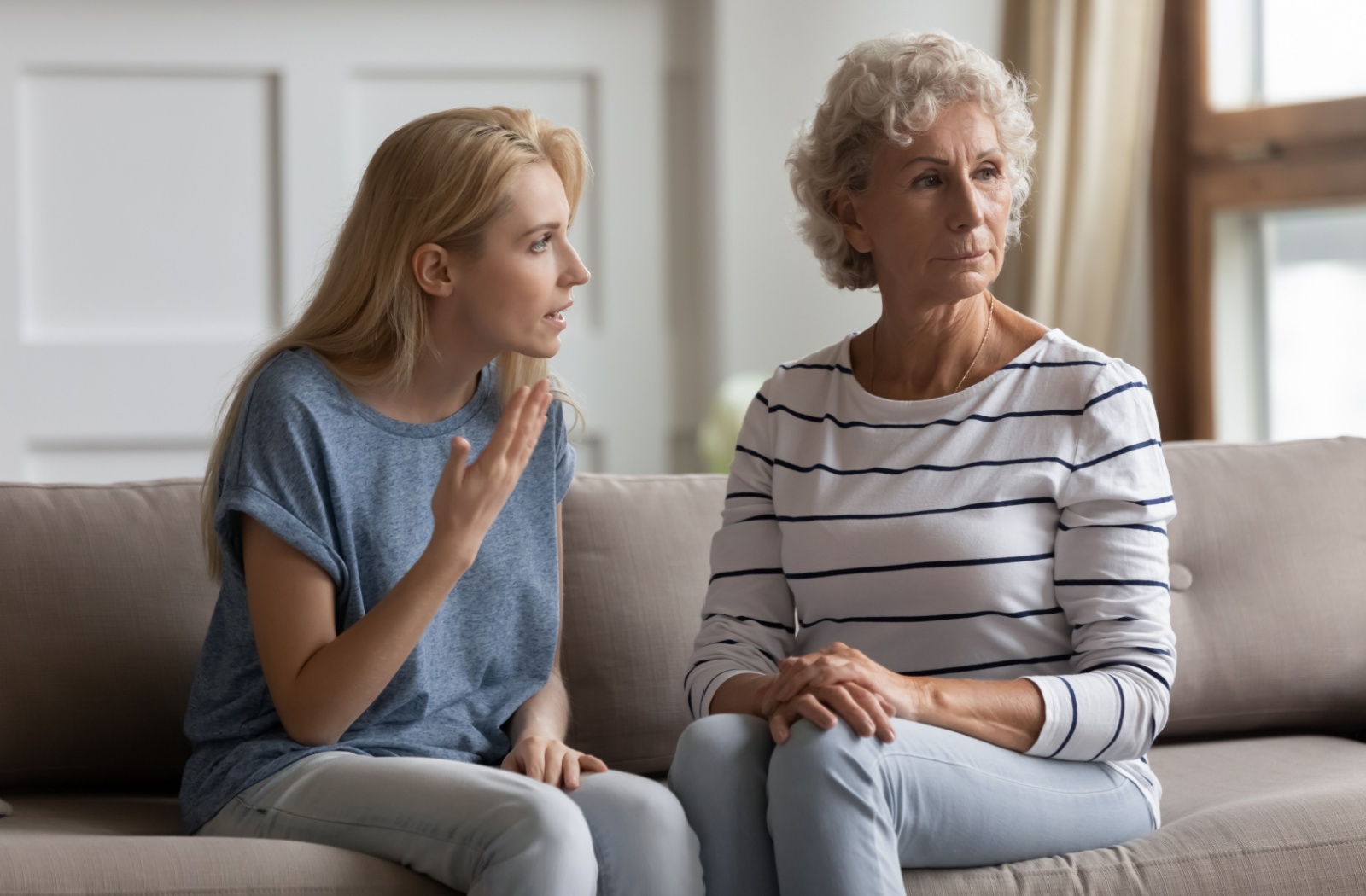 A younger adult voices their concerns to an older adult who looks uninterested