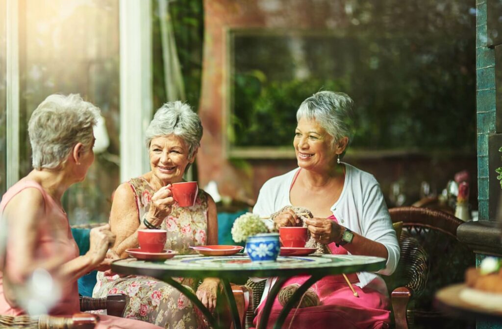 A group of older adults catch up and chat over coffee, strengthening their friendship and building emotional intimacy.