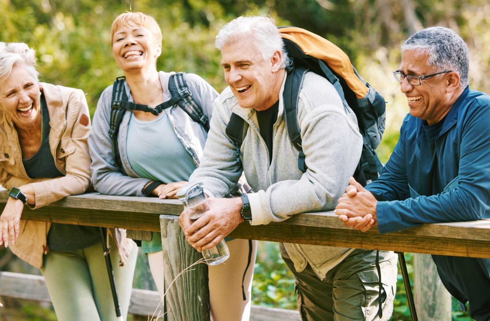 Older adults stop for a break together on their hike through a local nature trail.