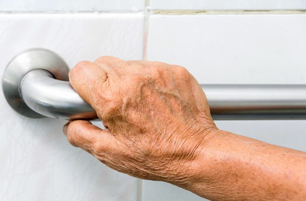 A close-up image of an older adult's hand grabbing a grab bar to keep them safe in their home.