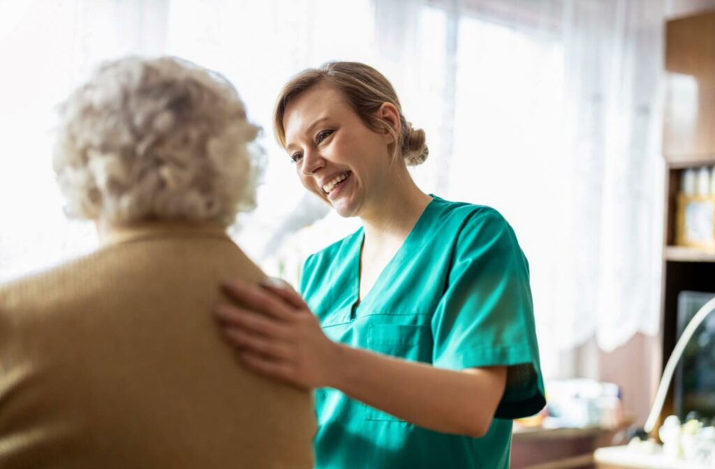 A smiling caregiver checks in on a happy resident in their home in memory care