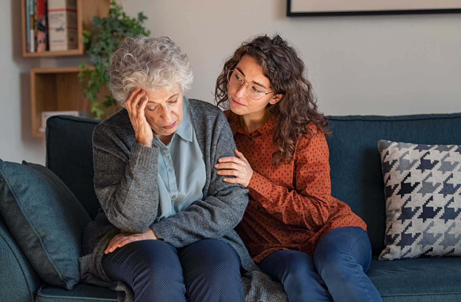 A loving adult child comforts their stressed senior parent.