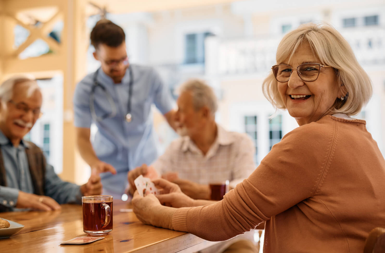 group of seniors drinking tea and enjoying card games