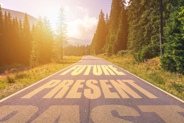 Past, Present, Future concept. Driving on an empty road in the mountains to the Future passing Present and leaving behind the Past.